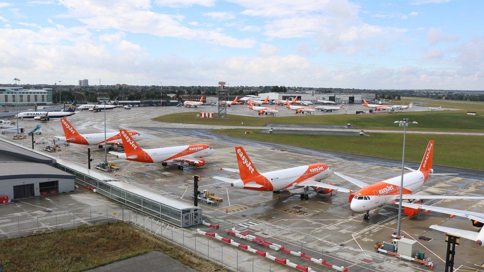 Four planes parked in a row on a runway branded with the easyJet logo