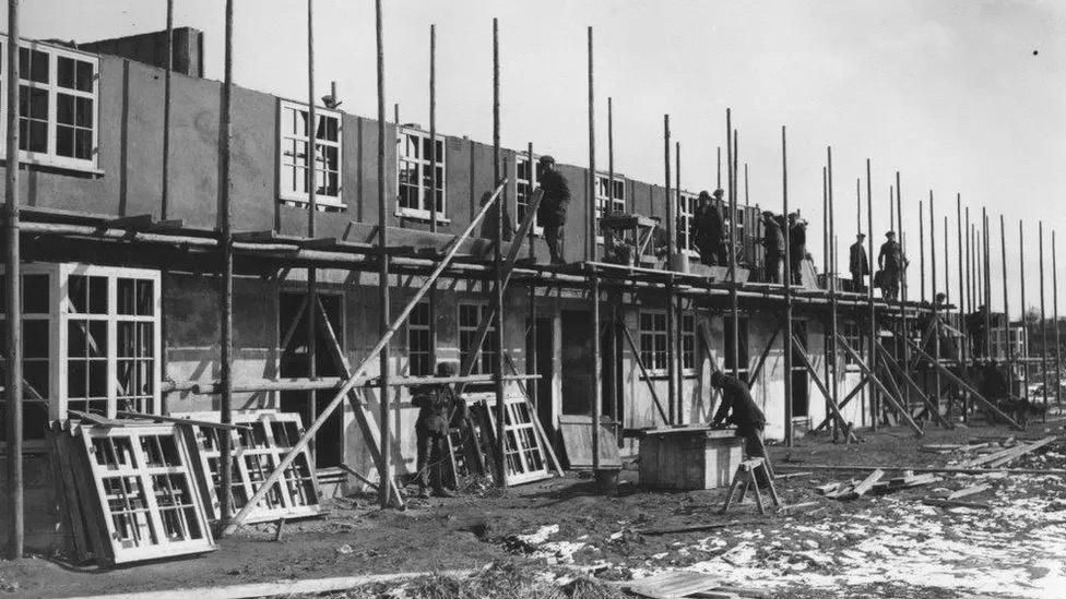 Back and white images of building working on a row of houses