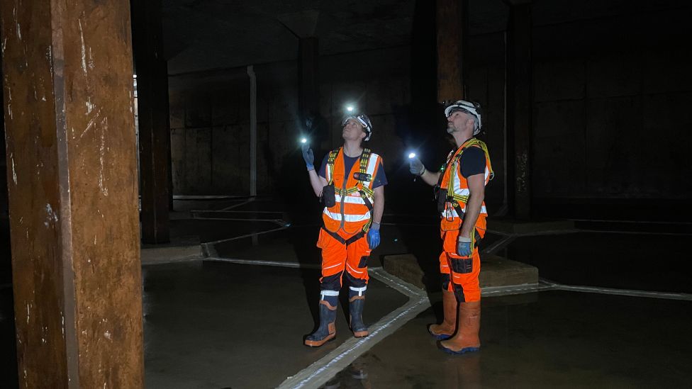 Two people with torches underground 