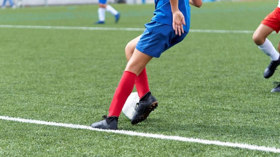 Boy playing on artificial grass pitch