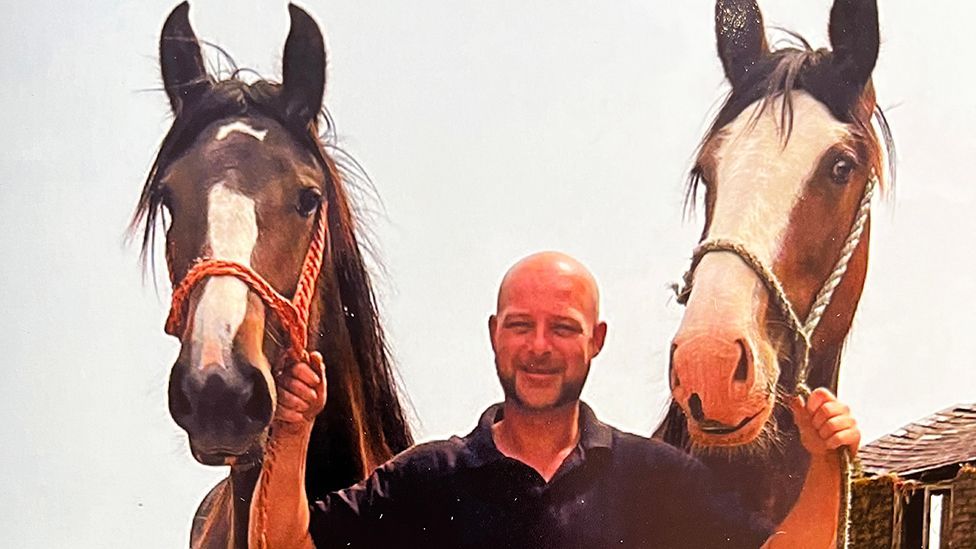Alex Chadwick holding the reins of two horses