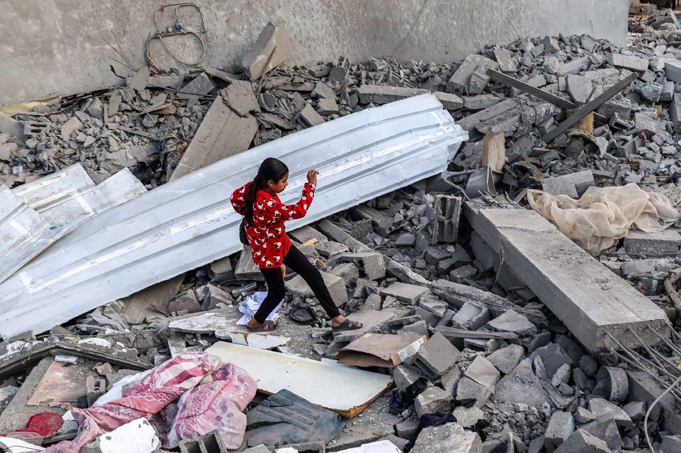 A girl walks through rubble in Rafah in the southern Gaza Strip on 24 April 2024