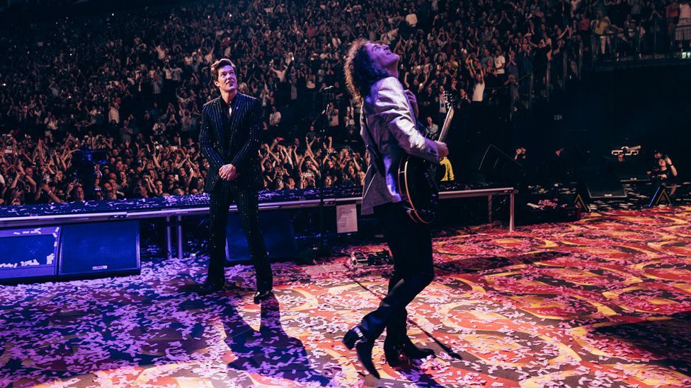 Brandon Flowers and Dave Keuning on stage looking up at the screen