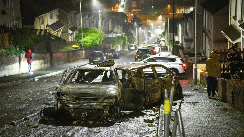 Burned out cars in a street in Mayhill following disorder