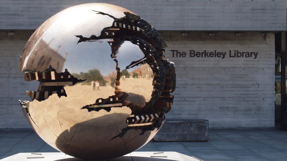 A silver orb sculpture outside the library