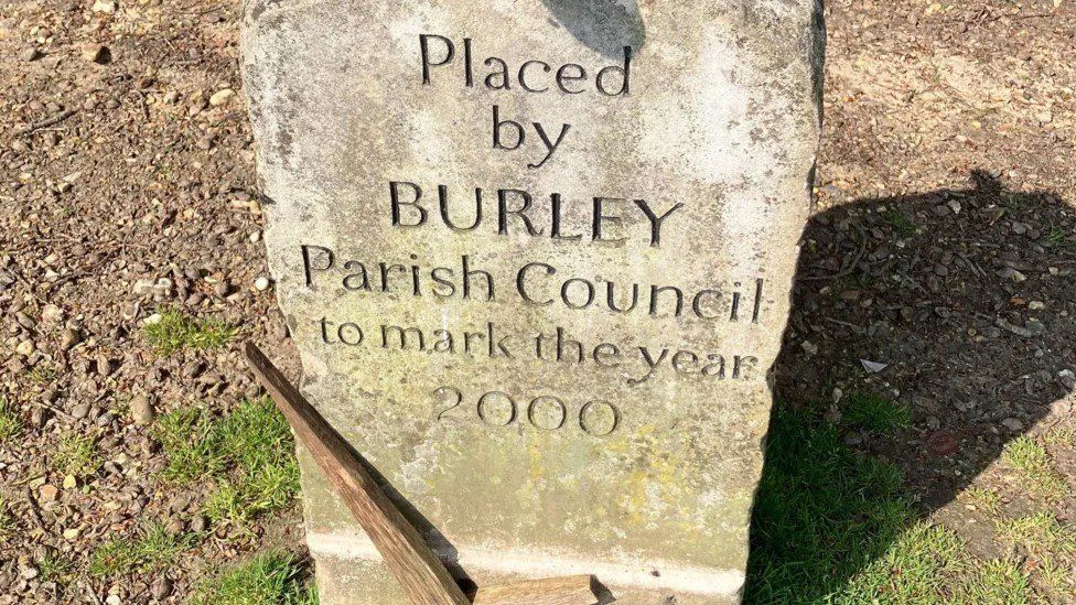 Burley memorial stone with wooden cross placed against it
