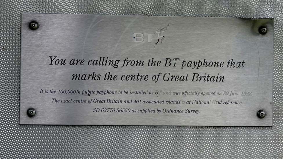 A plaque that says the payphone marks the centre of Great Britain