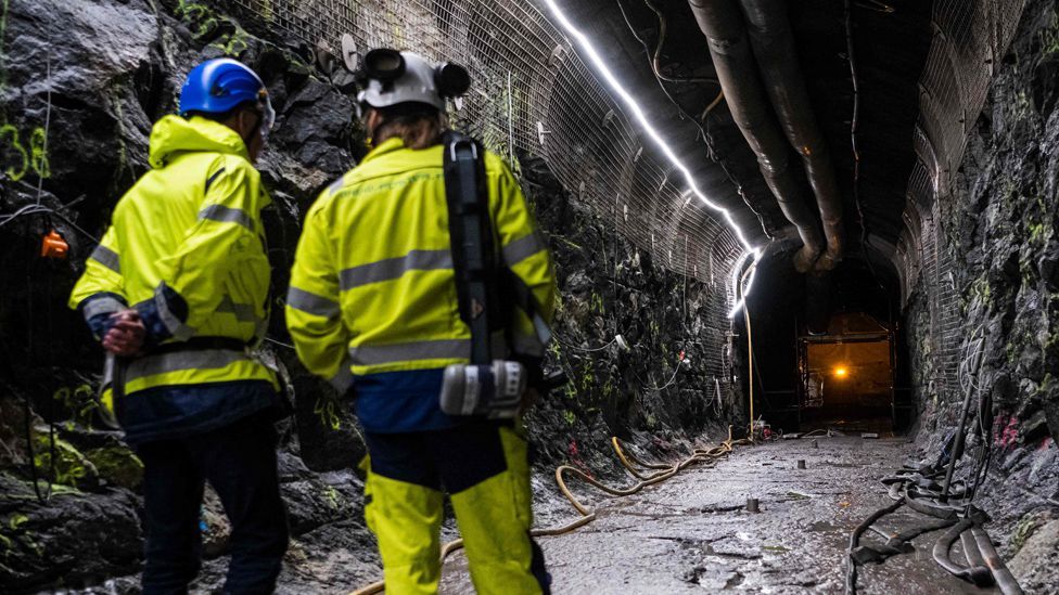 Two construction workers stand in a tunnel inside the underground  geological nuclear waste disposal facility in Finland 