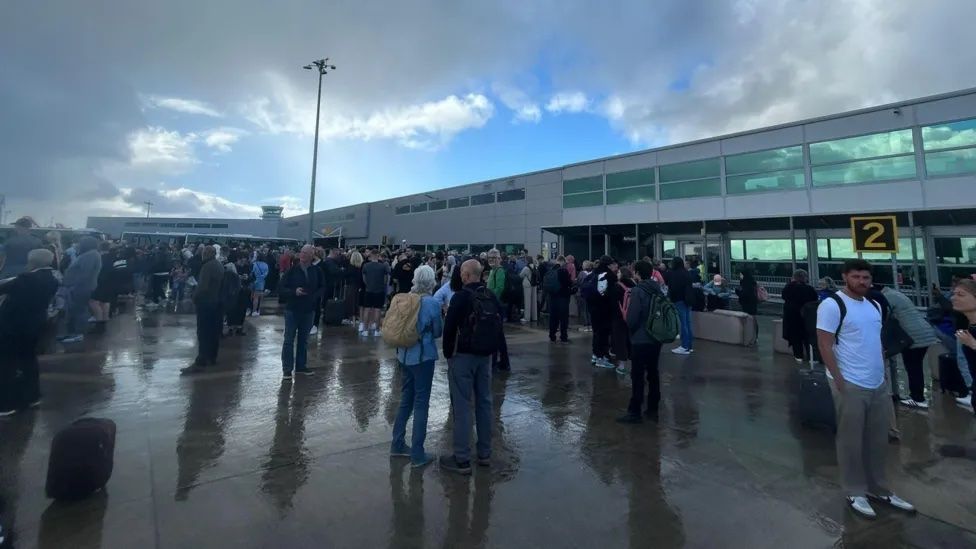 Passengers standing on the tarmac at Bristol Airport.