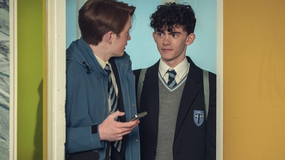 Two male teenagers dressed in school uniforms 
