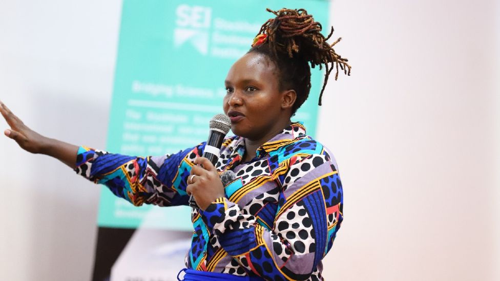 Dr Joyce Kimutai delivers a talk, while holding a microphone