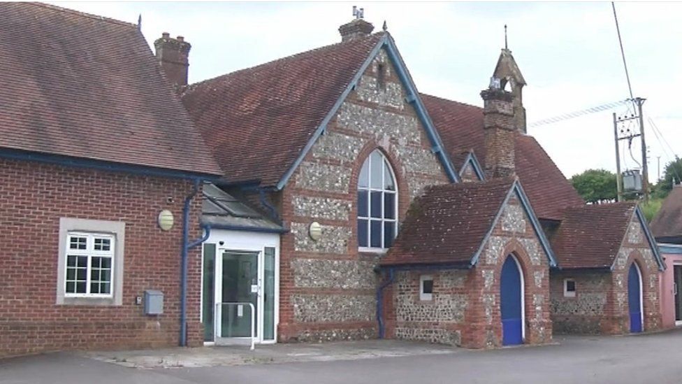 Winterborne Stickland former first school a brick and flint building with blue blue doors