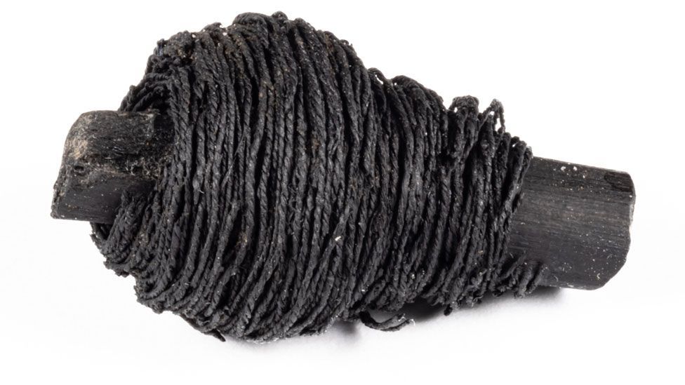 Bronze Age blackened thread wrapped around a blackened wooden stick from Must Farm