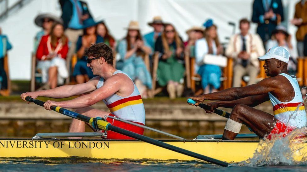 University of London crew in yellow boat with oar splashing in the water