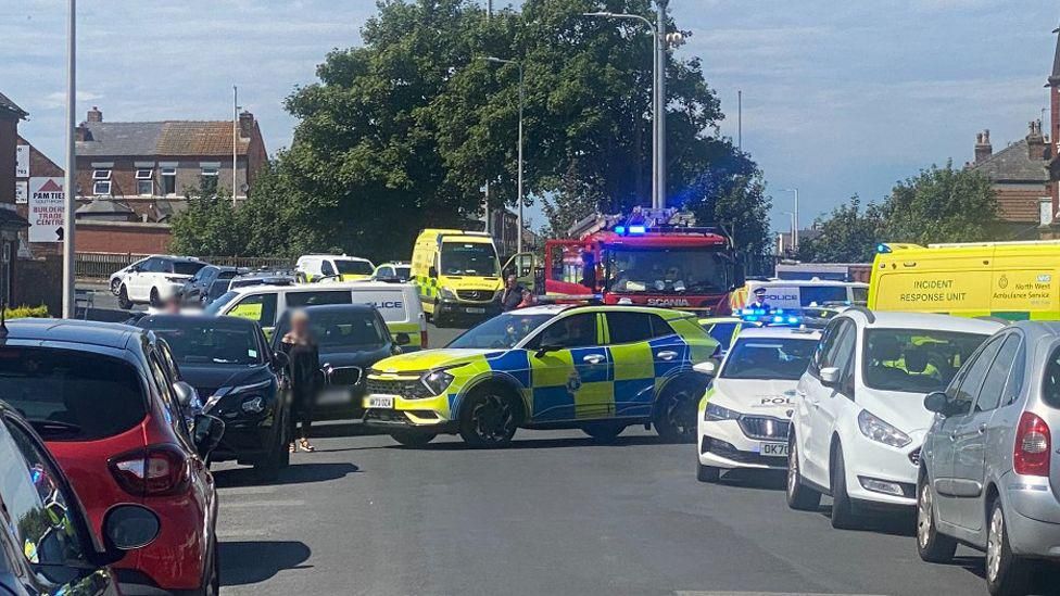 A police car blocks a busy road on Hart Street 