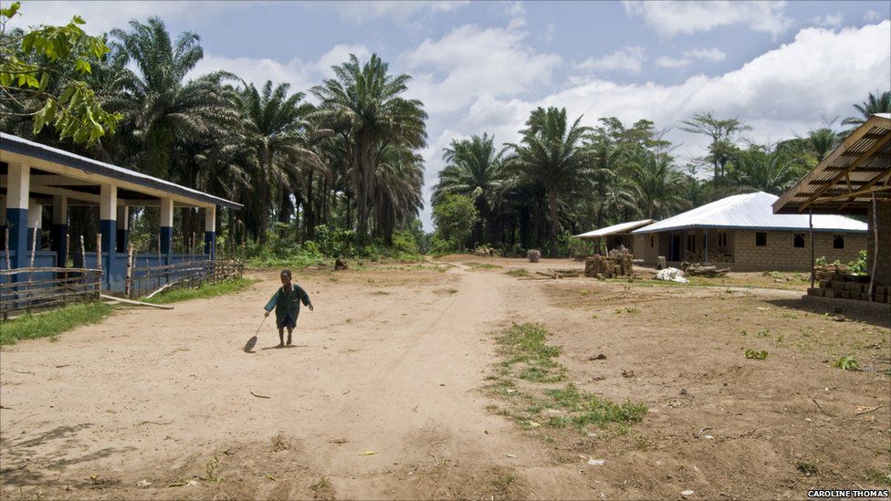 Boy playing with a stick and a wheel in the village of Bombohun