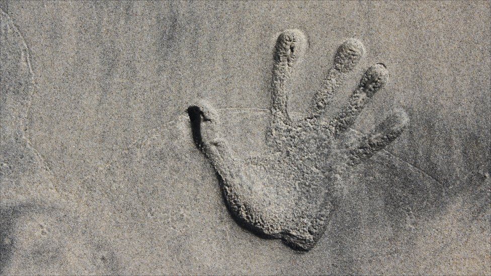 Woman's handprint on a beach in San Diego, California