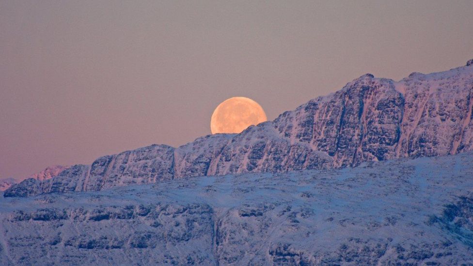 moon rising above mountains