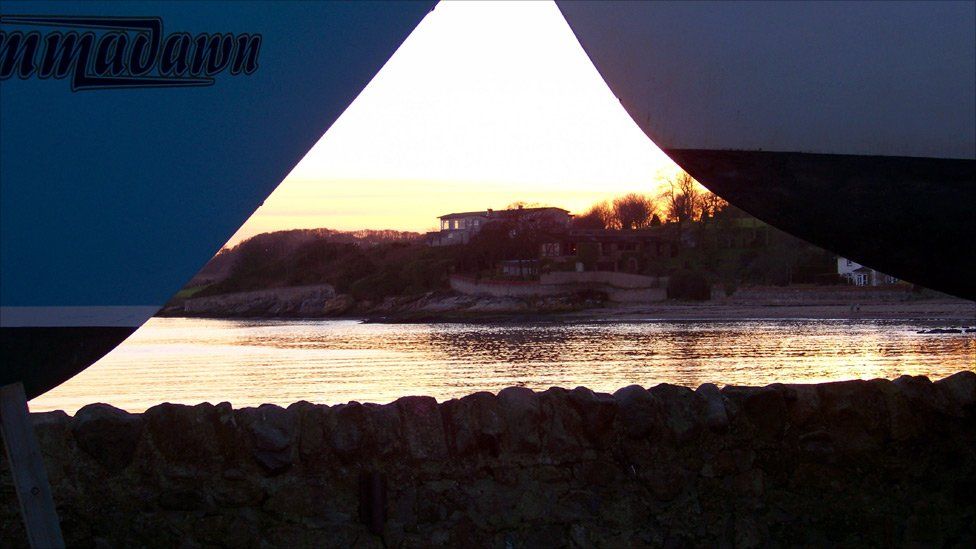 Houses along a shore at sunset