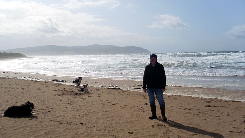 Martin and three Border collies on the beach
