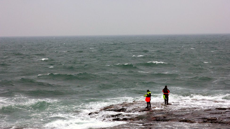 Fishermen standing on rocks