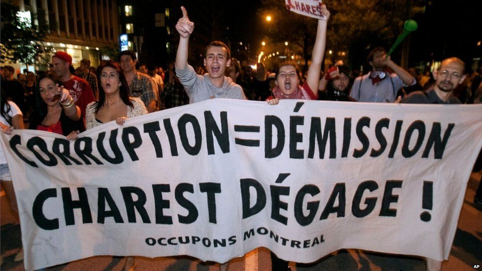 Protesters walk with a large banner in demonstrations against rising tuition fees in Montreal, Canada 23 May 2012