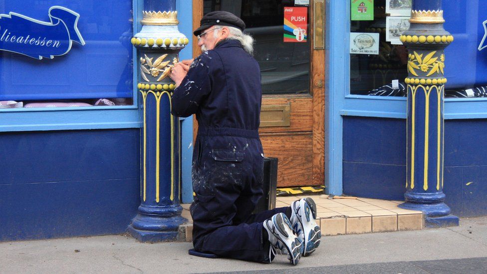 Jake Brown painting a shop front