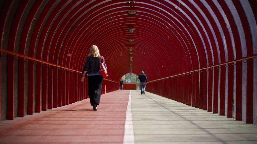 People walking through a covered walkway