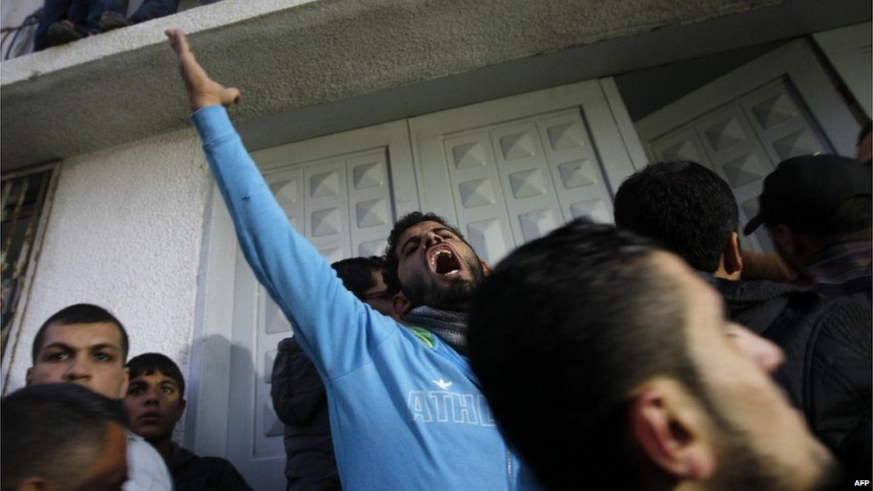 A Palestinian man raises his arm in anger at the hospital in Gaza where Jabari's body was brought