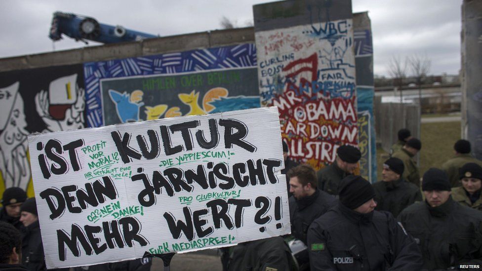 Protesters stand in front of the Berlin Wall, Germany