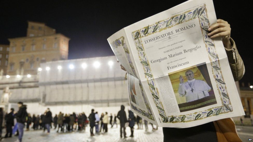A reader looks at the first edition of the Vatican newspaper L'Osservatore Romano after the election of Pope Francis