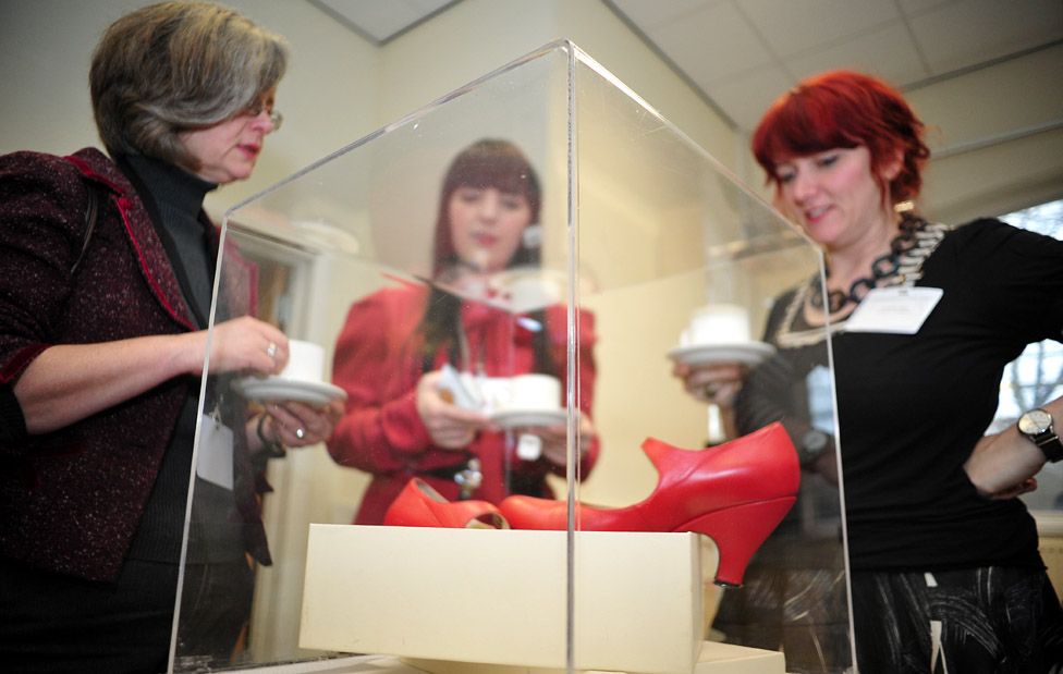 World at your Feet delegates admire a red pair of shoes designed by Vivienne Westwood