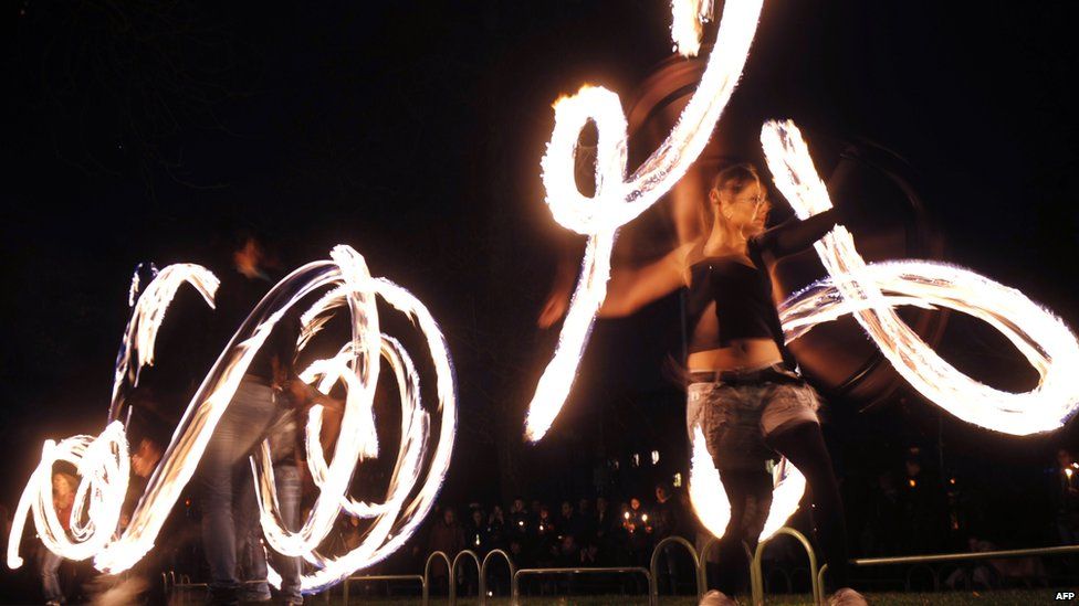 Fire acrobats perform in front of the Bulgarian National Theatre in Sofia during Earth Hour