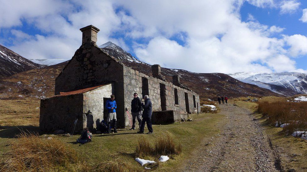 Walkers outside the remains of a croft house