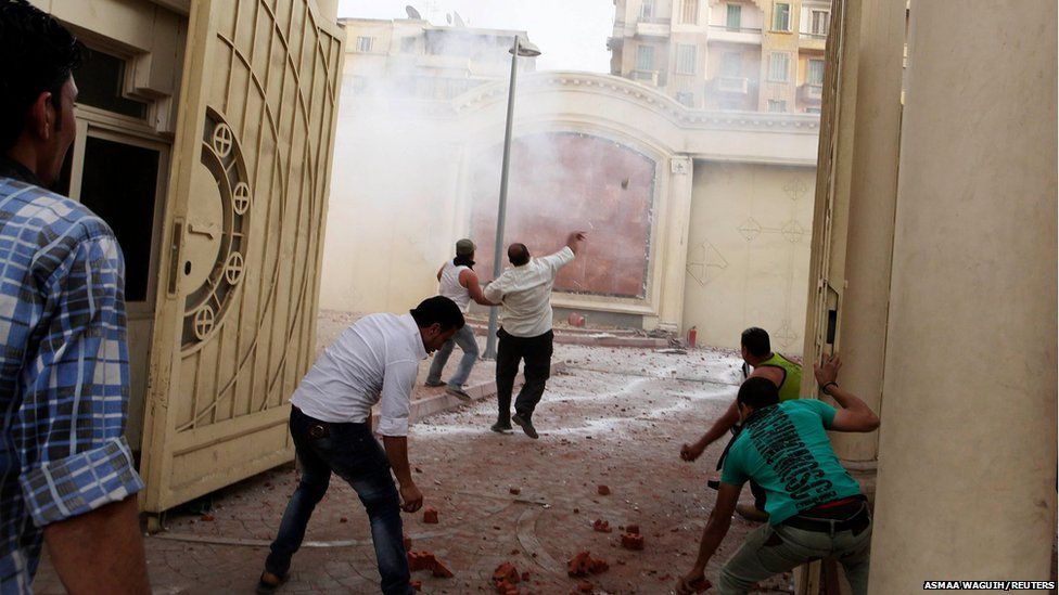 Coptic Christians throw stones inside the main cathedral during clashes