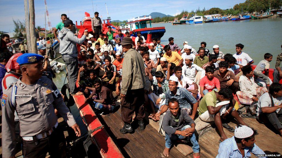 Rohingya migrants sit on the boat at a port in Aceh