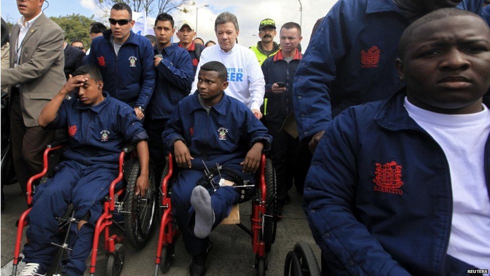 President Juan Manuel Santos pushes a soldier in a wheelchair during the march for peace in Bogota.