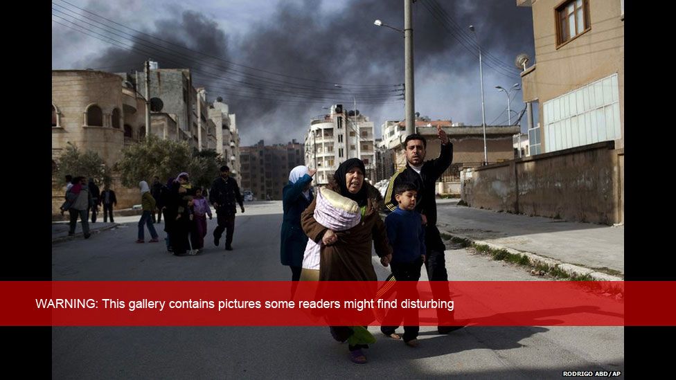 A family escapes from fierce fighting between Free Syrian Army fighters and government troops in Idlib, northern Syria, 10 March 2012