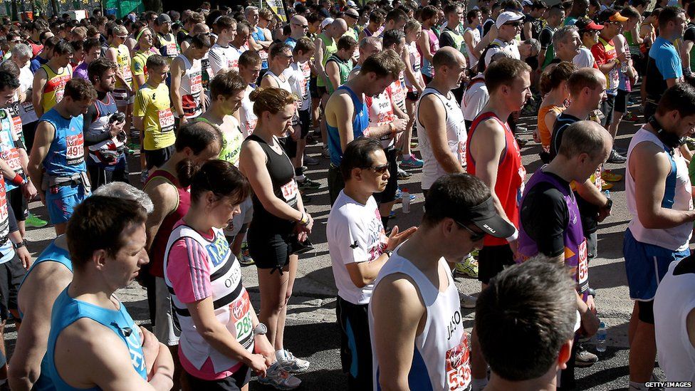 Runners stand in a silent tribute to the victims of the Boston Marathon bombings before the start of the London Marathon