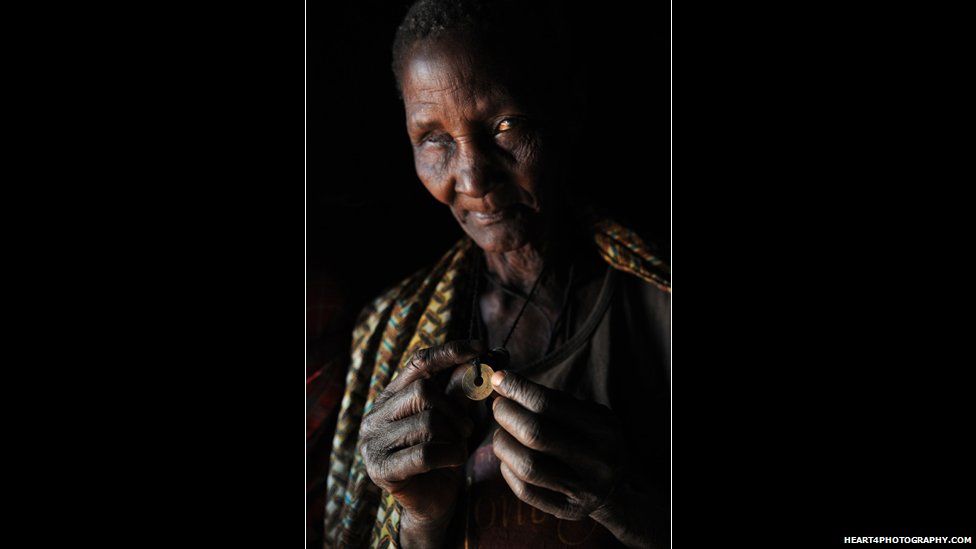 Wife of traditional healer in southern Tanzania holding a coin