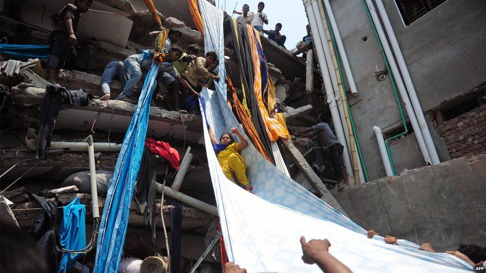 Bangladeshi garment workers help evacuate a survivor using lengths of textile as a slide after an eight-storey building collapsed in Savar, on the outskirts of Dhaka, on April 24, 2013.