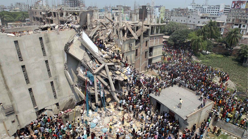 People and rescuers gather after an eight-story building housing several garment factories collapsed in Savar, near Dhaka, Bangladesh, Wednesday, April 24, 2013.