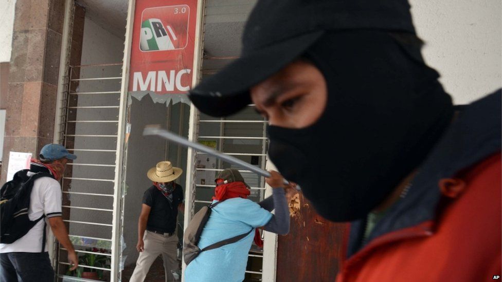 Groups of protesters break the windows of the PRI party's office in Chilpancingo, Guerrero on 24 April 2013