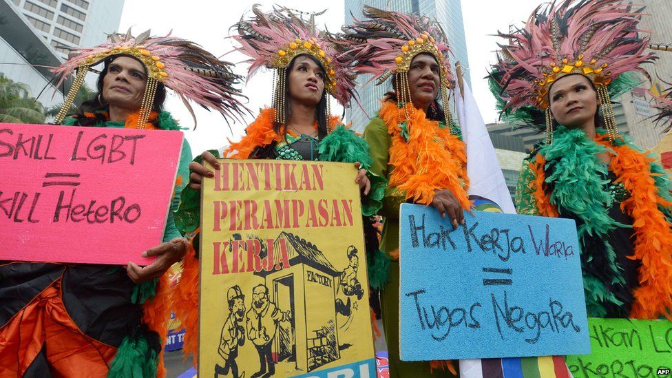 Indonesian transvestites hold placards as they participate in a May Day protest in Jakarta on May 1, 2013.