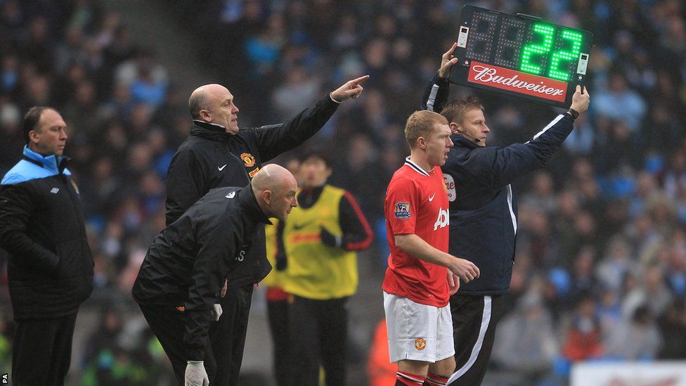Manchester City Coach David Platt (left) looks on as Manchester United's Paul Scholes (right) prepares to go onto the pitch