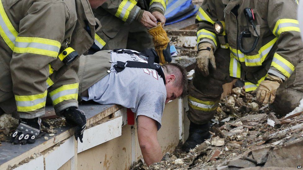 Rescue workers dig through the rubble of a collapsed wall at the Plaza Towers Elementary School in Moore