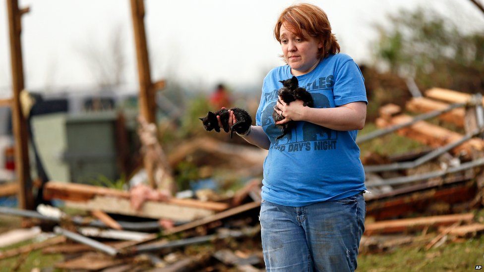 Rachel Hilton holds stray kittens found in the debris