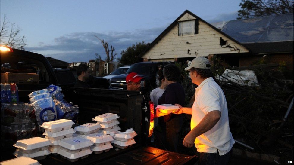 Derick Brock from Mercy Chefs distributes hot food to tornado victims at their devastated neighbourhood 21 May, 2013 in Moore, Oklahoma.