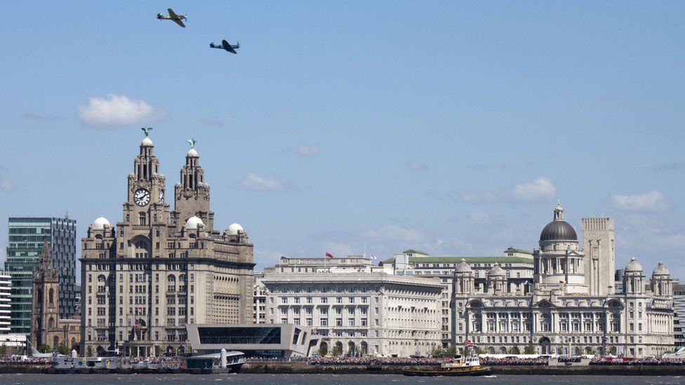 Two spitfire airplanes flying over the Liverpool Three Graces to mark the 70th anniversary of The Battle of the Atlantic. Photo: Mathieu Bangert