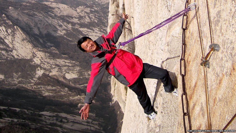 Man poses on Chang Kong Cliff Road in Shaanxi province, China